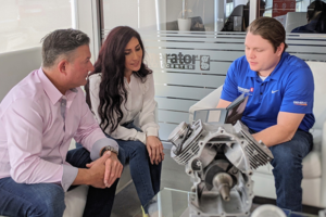 Generator technician discussing a generator component with homeowners in a showroom