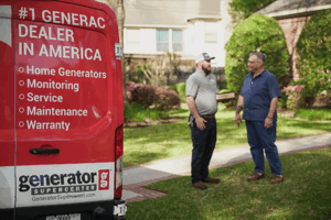 Two people discussing a home generator installation beside a Generator Supercenter van
