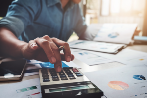 person reviewing home generator costs and tax documents with a calculator