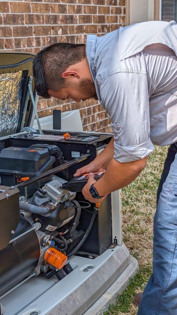 Technician servicing a standby generator outdoors