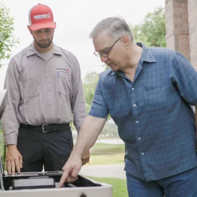 Technicians inspecting a standby generator during home generator maintenance.