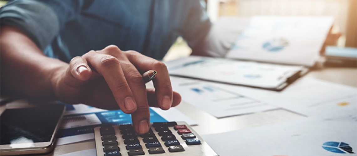 person reviewing home generator costs and tax documents with a calculator