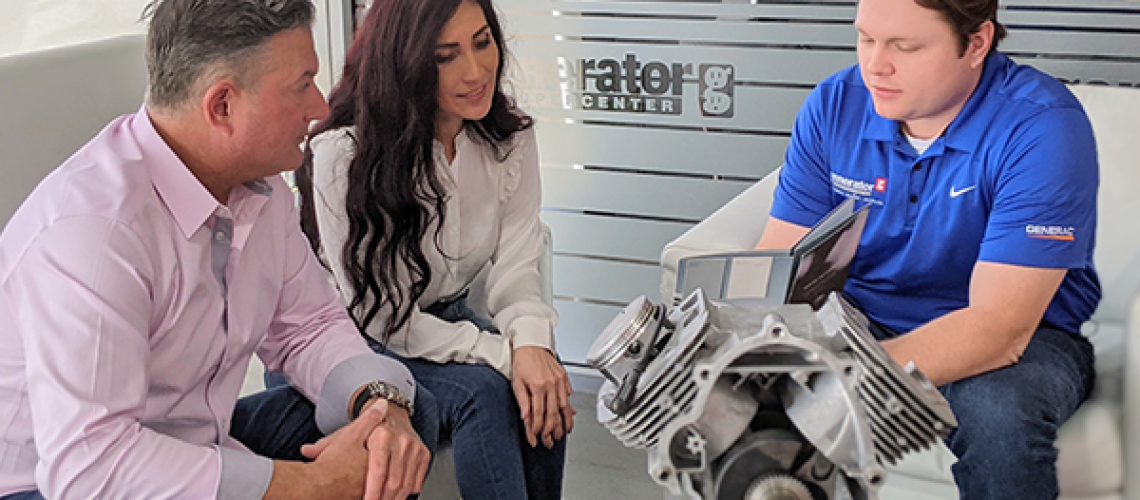 Generator technician discussing a generator component with homeowners in a showroom
