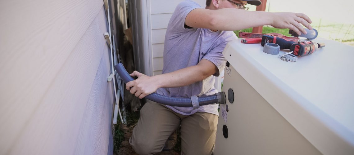 Technician installing a transfer switch for a home standby generator