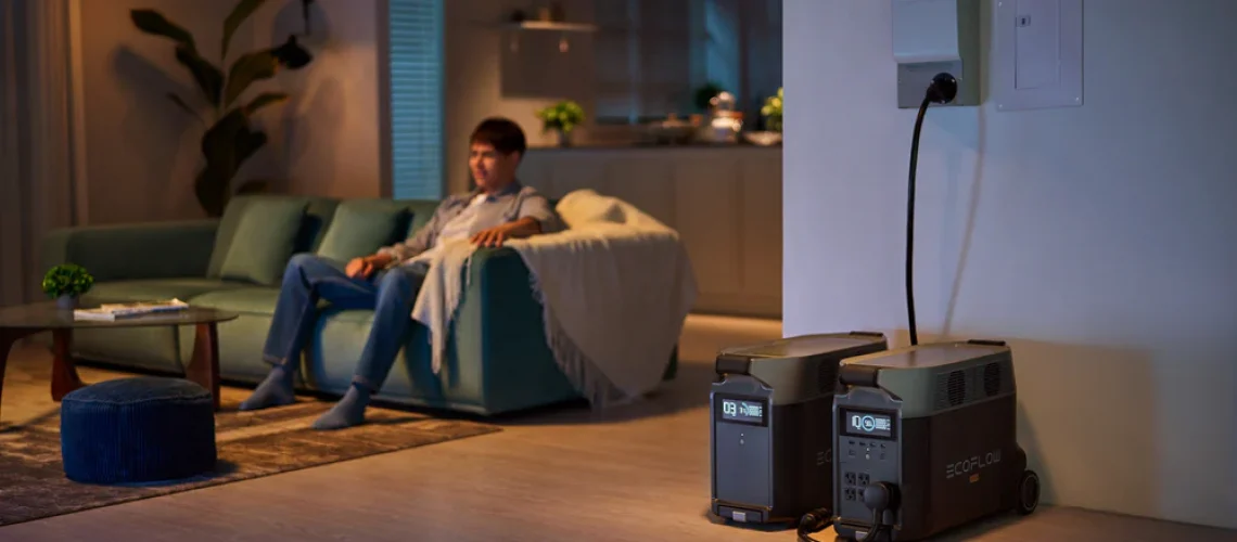 Man on sofa during a nighttime power outage with emergency backup power nearby