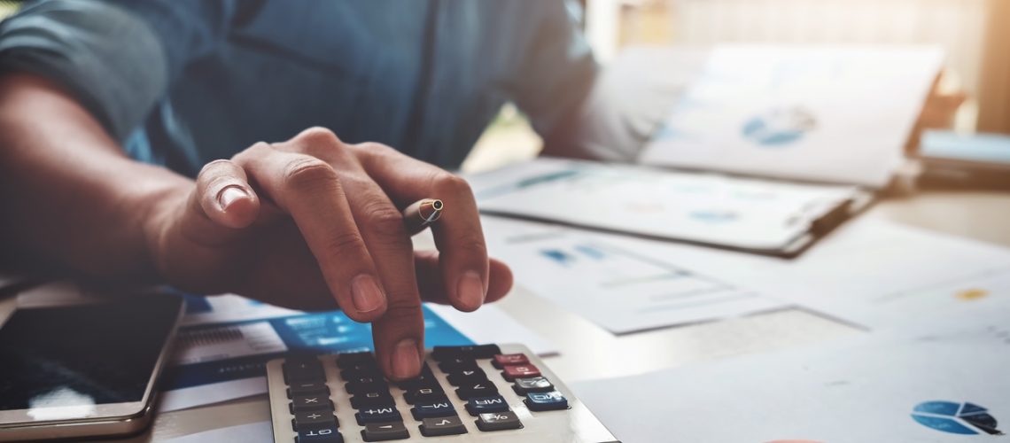 Business accounting concept, Business man using calculator with computer laptop, budget and loan paper in office. Business accounting concept, Business man using calculator with computer laptop, budget and loan paper in office.